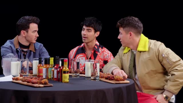 S09:E01 - The Jonas Brothers Burn Up While Eating Spicy Wings